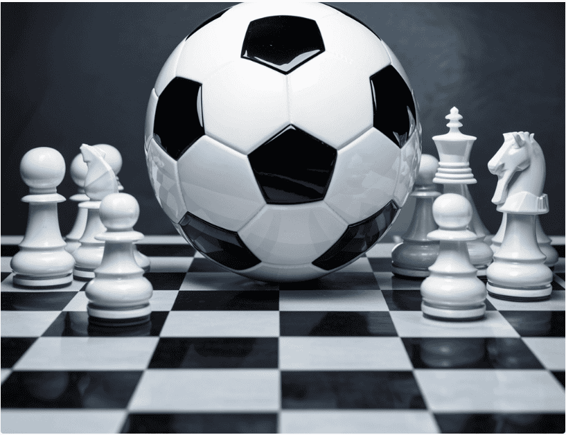 A soccer ball and chess pieces on the ground.
